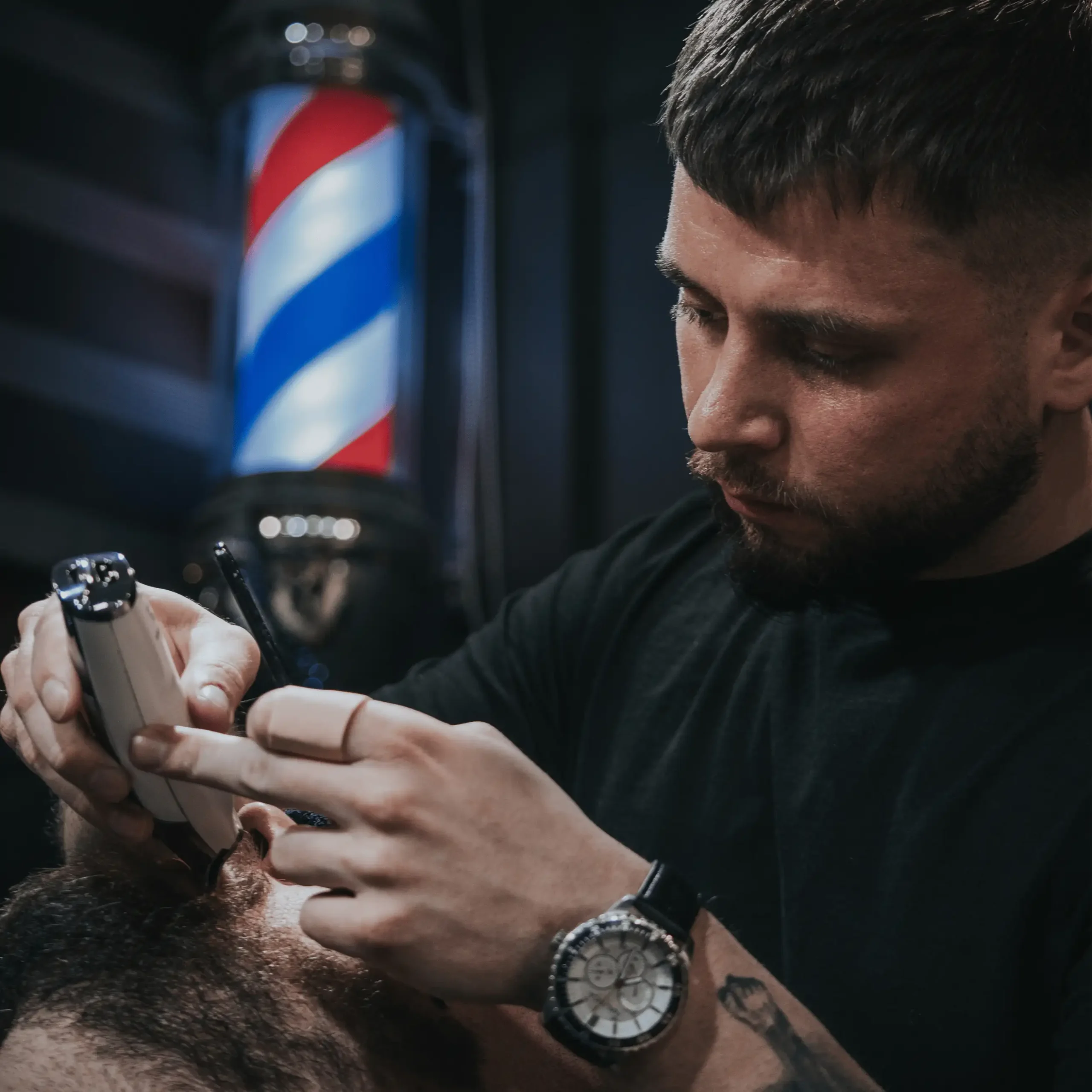 Barber strzyżący brodę klienta.